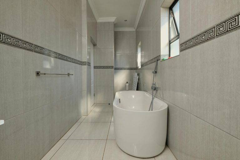 Sleek modern bathroom featuring a freestanding tub, elegant tiles, and natural light.