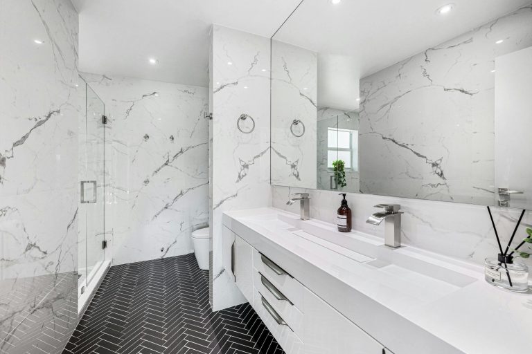 Explore the elegance of a modern bathroom featuring marble walls and sleek fixtures.